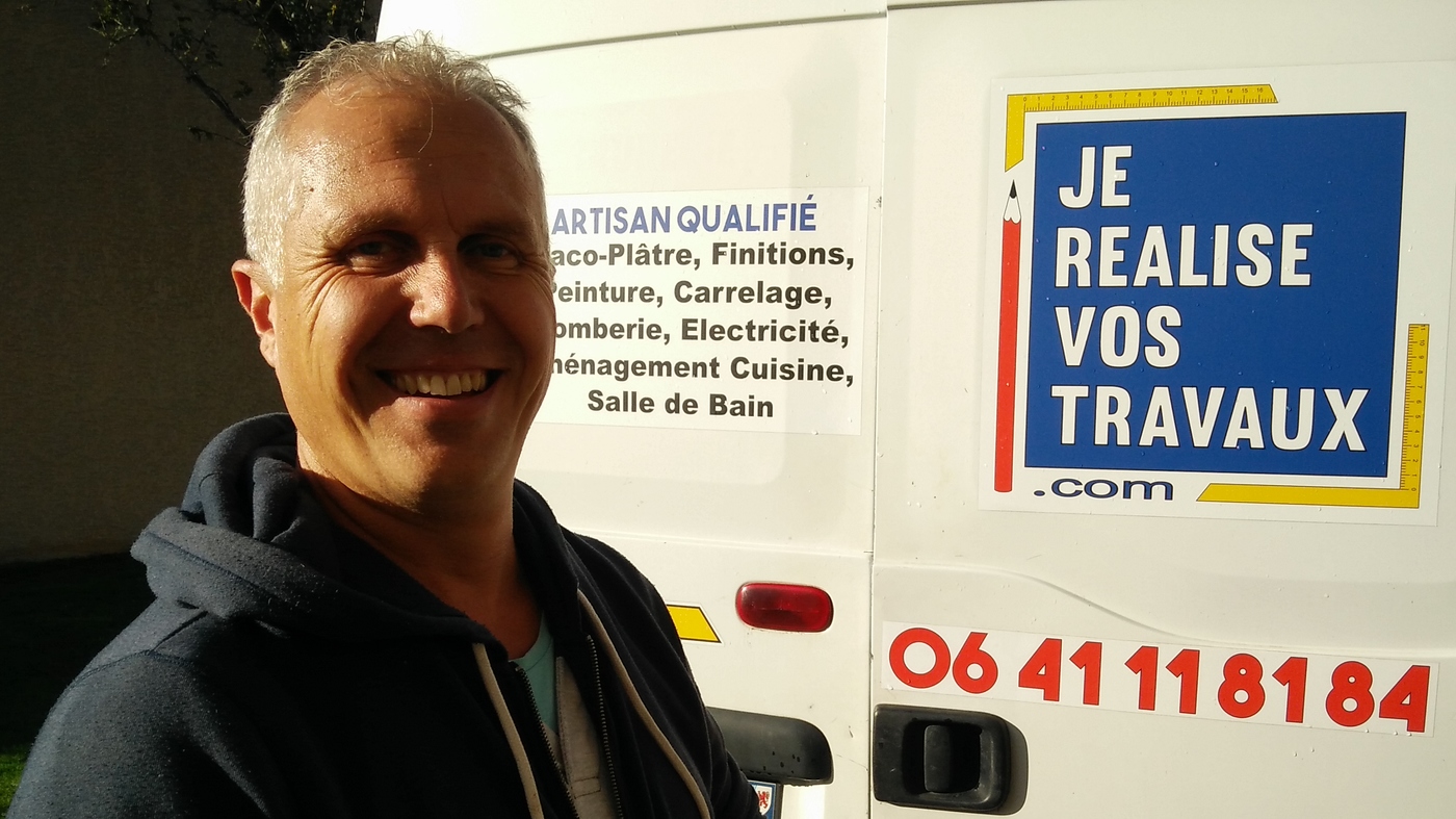 Cyrille devant son camion décoré du logo